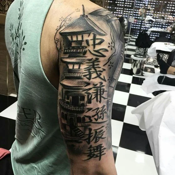Japanese script and pagoda tattoo design for men on upper arm