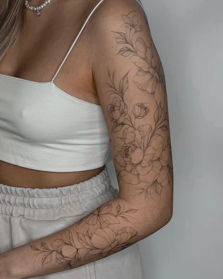 Linework floral flower tattoo design for women on upper arm and forearm