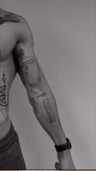 Men's fine line patchwork tattoo: rose, compass, quote on arm.