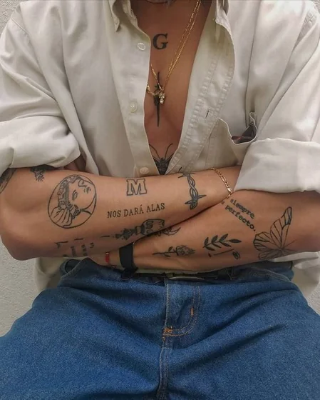 Men's patchwork fine line butterfly, rose, initial tattoos on forearm & chest.