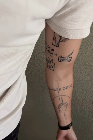 Men's patchwork fine line forearm tattoo idea: floral, classical bust, numbers, quote.