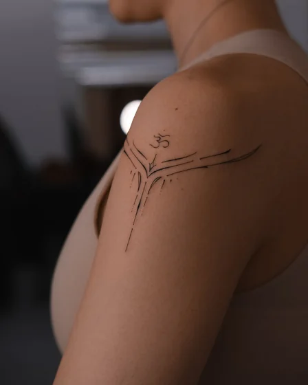 Minimalist Fine Line Om symbol tattoo idea for women on shoulder