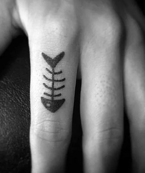 Minimalist blackwork fish tattoo idea for men and women on finger
