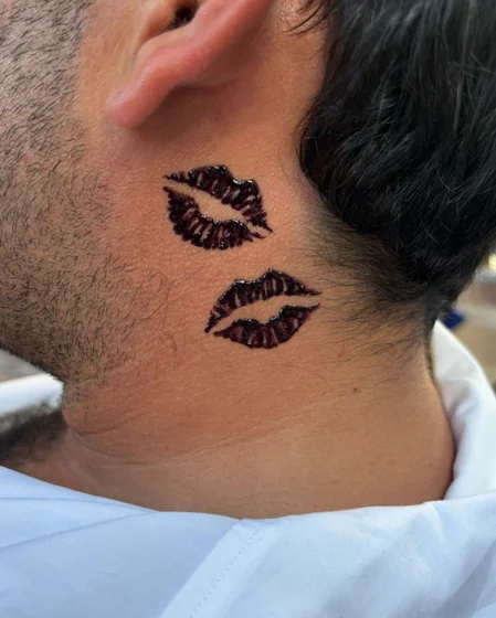 Minimalist blackwork kiss mark tattoo for men on neck, behind ear.