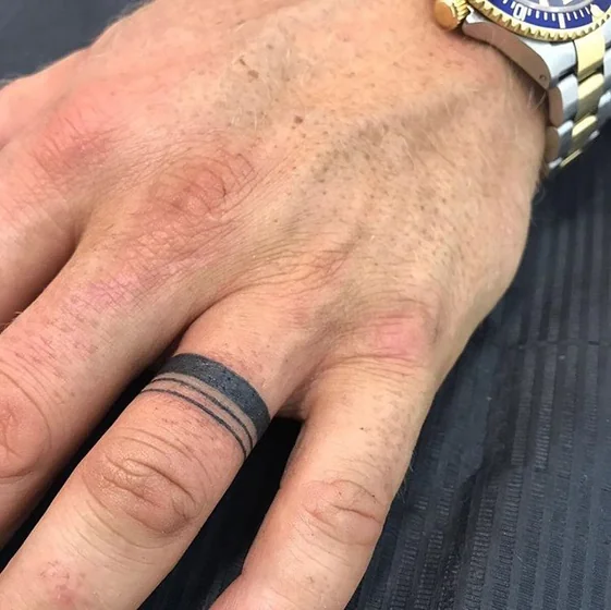 Minimalist blackwork ring tattoo design for men on finger