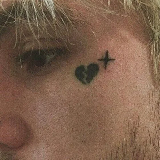 Minimalist broken heart and star tattoo idea for men on face
