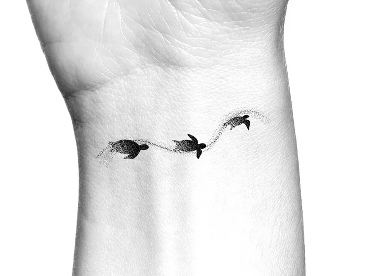 Minimalist dotwork turtle tattoo design for men and women on wrist