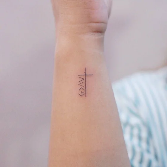 Minimalist faith symbol cross tattoo for women on forearm