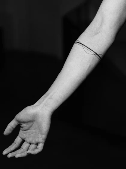 Minimalist fine line arm band tattoo design for women on forearm