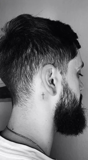 Minimalist fine line cross tattoo design for men on neck behind the ear