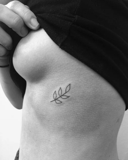 Minimalist fine line floral tattoo design for women on rib