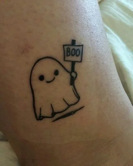 Minimalist fine line ghost with 'Boo' sign tattoo idea on leg
