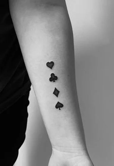 Minimalist fine line playing card suits tattoo for women on forearm
