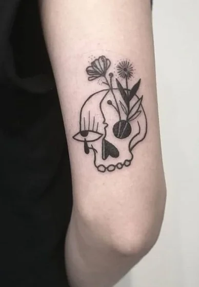 Minimalist fine line skull and flower tattoo design for women on upper arm