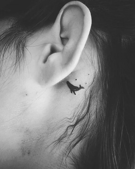 Minimalist fine line whale tattoo design for women behind the ear