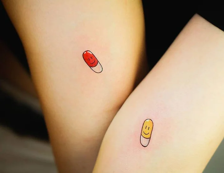Minimalist happy pill tattoo idea for women on thigh