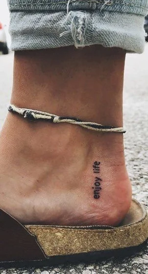 Minimalist script 'enjoy life' quote tattoo for women on ankle