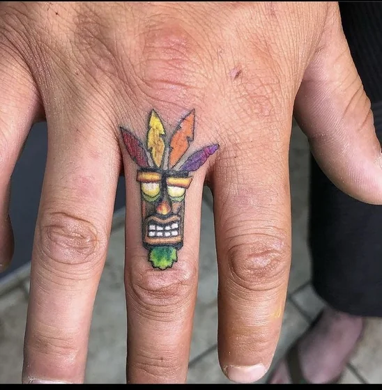 New School Aku Aku Mask video game tattoo design for men on finger