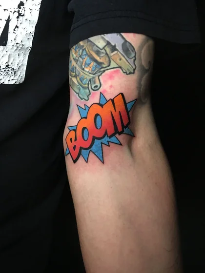 New School Comic Book 'BOOM' sound effect tattoo for men on upper arm