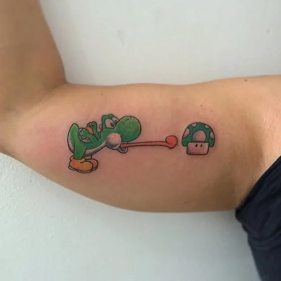 New School Yoshi and Super Mushroom video game tattoo idea on bicep