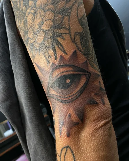 Patchwork blackwork eye and floral tattoo idea for men and women on arm