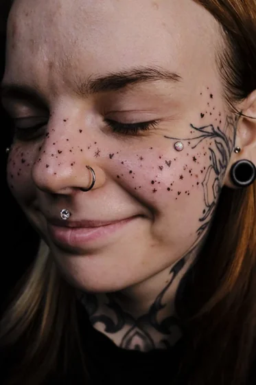 Patchwork blackwork floral, star, heart tattoo design for women on face