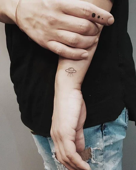 Patchwork fine line UFO and dots tattoo idea for women on wrist and finger