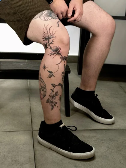 Patchwork fine line floral and star tattoo design for men on knee and calf