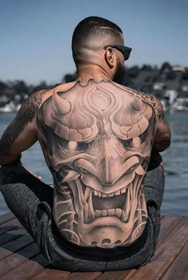 Realistic Black And Grey Oni Mask tattoo design for men on back