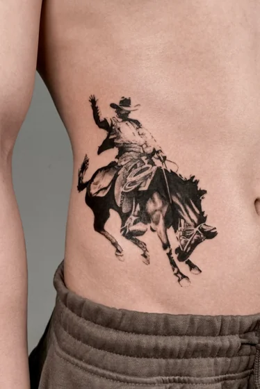Realistic Black And Grey cowboy and horse tattoo design for men on rib and hip