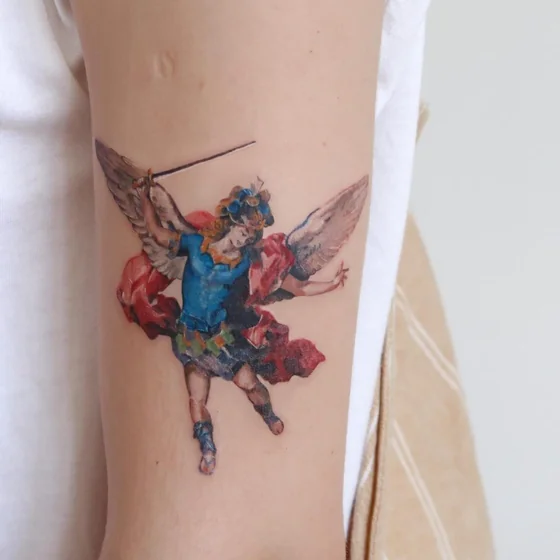 Realistic Saint Michael angel tattoo design for women on upper arm
