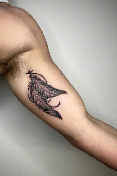 Realistic and fine line feather tattoo design for men on bicep