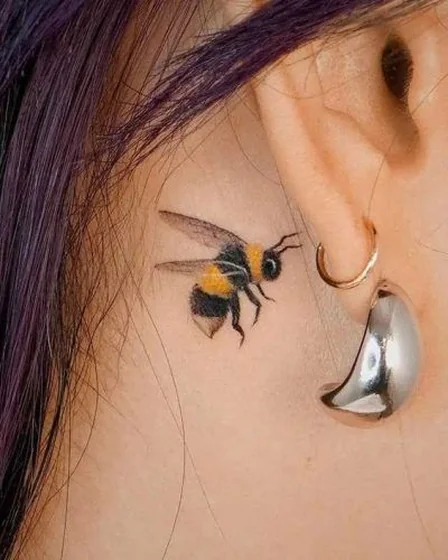 Realistic bee tattoo design for women behind the ear
