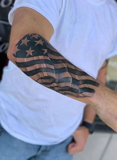 Realistic black and grey American Flag tattoo for men on arm