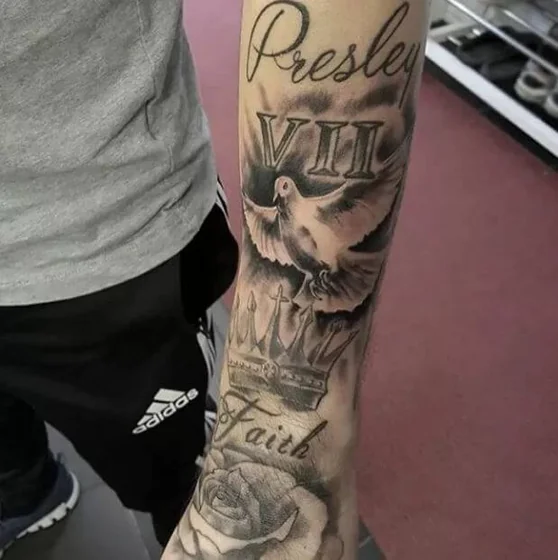 Realistic black and grey dove, crown, rose, and script tattoo for men on forearm