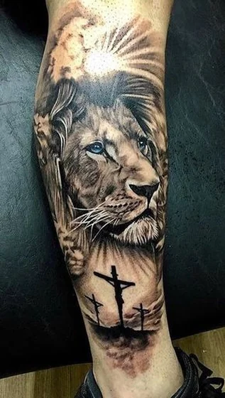 Realistic black and grey lion and cross tattoo design for men and women on calf