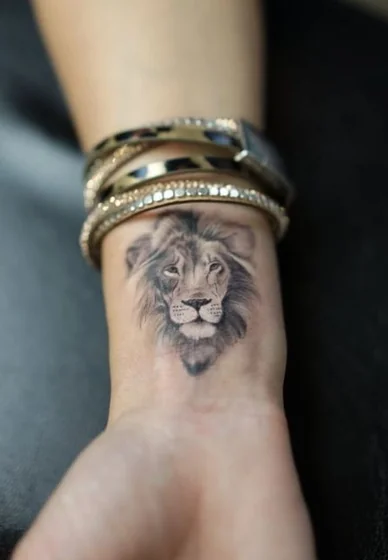 Realistic black and grey lion tattoo design for women on wrist