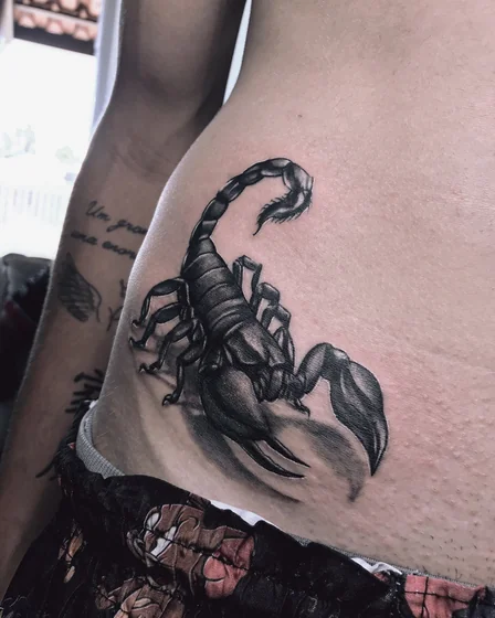 Realistic black and grey scorpion tattoo idea for men on hip/rib