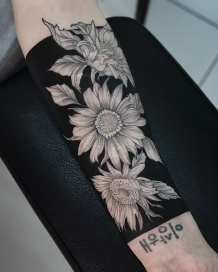Realistic blackwork sunflower and floral tattoo design for women on forearm