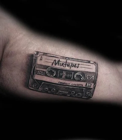 Realistic cassette tape tattoo design for men on bicep