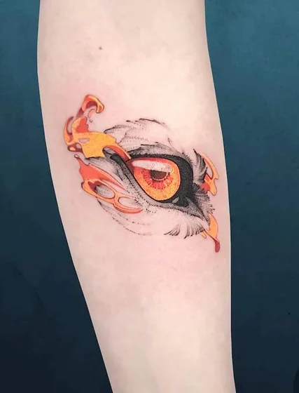 Realistic eagle eye with illustrative flame tattoo design for women on forearm