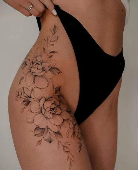 Realistic fine line floral tattoo design for women on thigh and hip