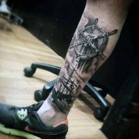 Realistic ocean, ship's wheel, sailing ship tattoo idea for men on calf and ankle