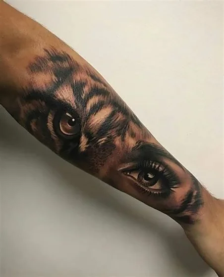 Realistic tiger and human eye tattoo design for women on forearm