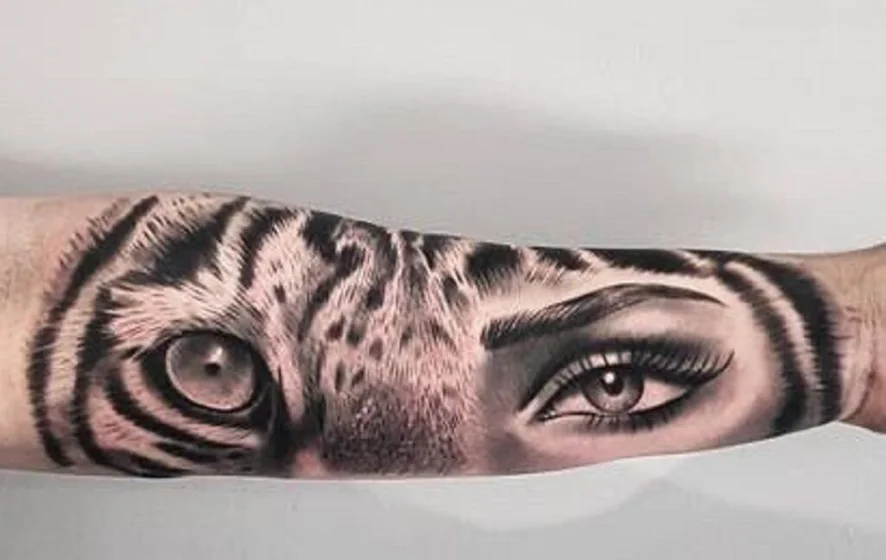Realistic tiger and human eye tattoo design for women on forearm