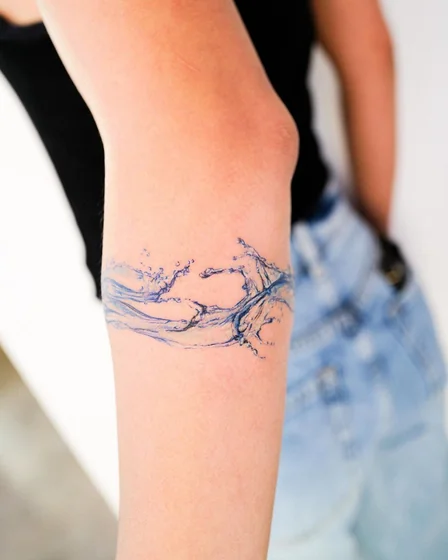 Realistic water splash linework tattoo design for women on upper arm