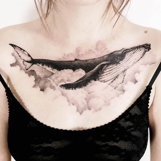 Realistic whale and cloud tattoo design for women on chest