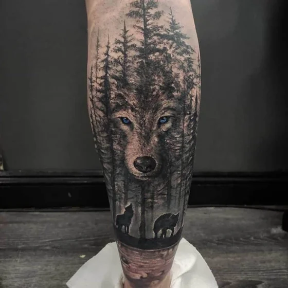 Ideia de tatuagem realista de lobo e floresta para homens e mulheres na panturrilha