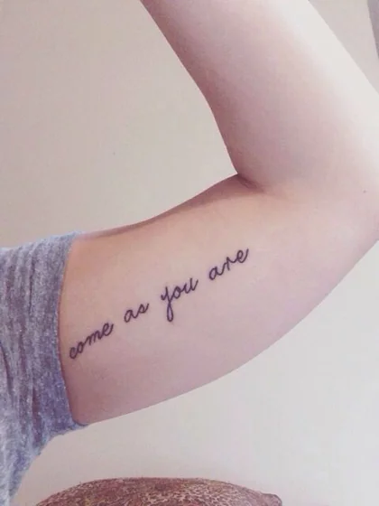 Script fine line quote tattoo design for women on upper arm