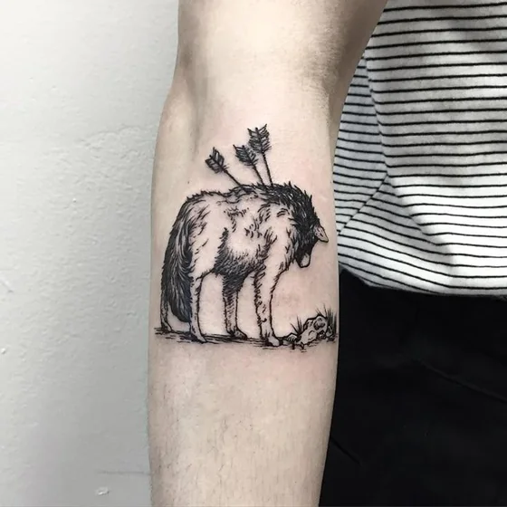 Sketchy blackwork wolf and arrow tattoo idea for men and women on upper arm
